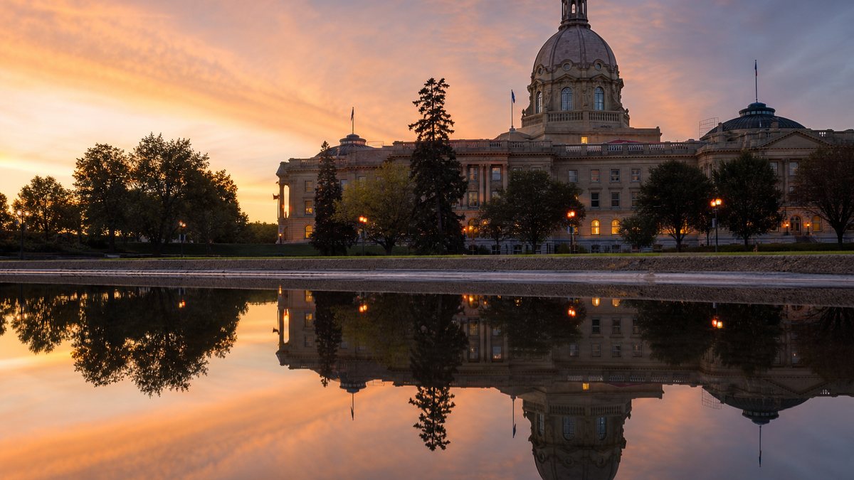 Alberta Legislature building reflected in water at dusk, illustrating Alberta's 2026 online casino launch